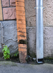 Water drainage solutions on a city street with damaged and intact pipes in a residential area