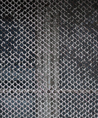 Close up of a weathered metal fence showing rust and wear in an urban setting during the afternoon