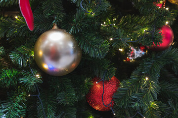 Golden and Red Baubles Hanging on a Christmas Tree with Sparkling Lights