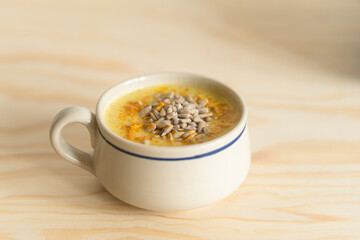 Creamy Yellow Soup with Sunflower Seeds and Turmeric in Rustic Mug