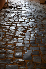 Uneven cobblestone path leads through a charming historical neighborhood in the early morning light