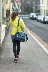 Young woman walks in the city alone
