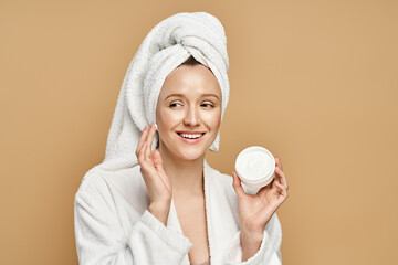 Radiant woman in towel shares her skincare secrets in a minimalist studio space