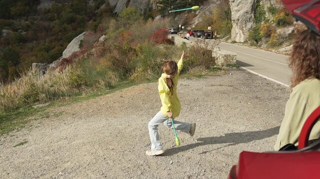 Active Road Trip Break Young Girl Juggling Sticks High Above Mountain View