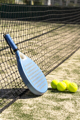 Tennis net stretches across frame with blue padel paddle hanging; perspective lines and selective focus create depth for padel, tennis, sportlife court lifestyle scenes.