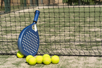Close-up padel rackets and bright tennis balls on an outdoor court near the net. Sport gear in sunlight with selective focus, capturing active lifestyle and modern sportlife.
