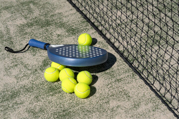 Close-up padel rackets and bright tennis balls on an outdoor court near the net. Sport gear in sunlight with selective focus, capturing active lifestyle and modern sportlife.