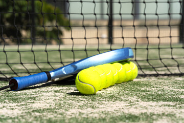 Close-up padel rackets and bright tennis balls on an outdoor court near the net. Sport gear in sunlight with selective focus, capturing active lifestyle and modern sportlife.