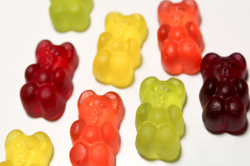 gummy bears in rainbow colors arranged casually showing glossy surface and classic bear candy shape details