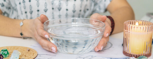 Ceromancy wax divination ritual with astrological charts, crystals, and runes on a table