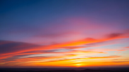 Fototapeta premium Vibrant panoramic skyscape showcasing a dynamic interplay of orange yellow and purple hues during the dusk hours