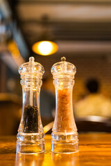 Grinders with pepper and pink Himalayan salt for culinary seasoning and gourmet cooking.