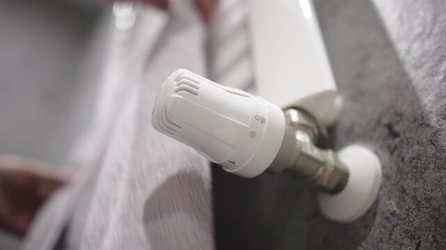 Adjusting the temperature on a radiator to ensure comfort and energy efficiency. Concept home energy efficiency and cozy living