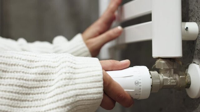 Adjusting the temperature on a radiator to ensure comfort and energy efficiency. Concept home energy efficiency and cozy living
