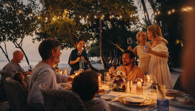 Luxurious family dining on a tropical island under twinkling lights