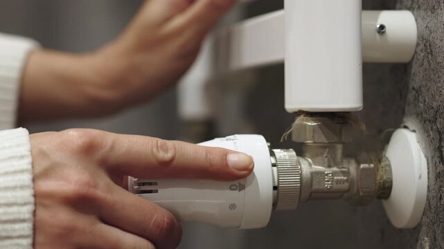 Adjusting the temperature on a radiator to ensure comfort and energy efficiency. Concept home energy efficiency and cozy living