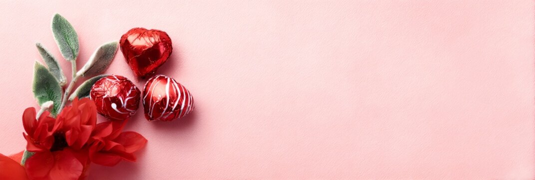 Pink background with three red hearts and a red flower
