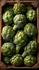 Obraz premium Fresh green artichokes gathered in a rustic wooden crate for market display