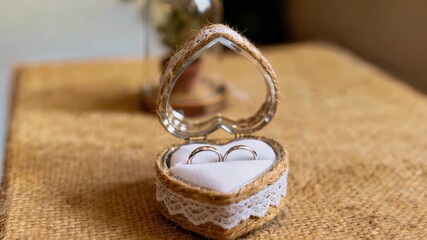 Romantic heart shaped wedding ring box displayed on rustic table surface symbolizing love commitment celebration and marriage ceremony atmosphere
