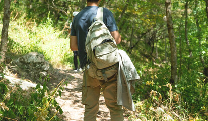 Naklejka premium Human with a backpack walk a forest path.
