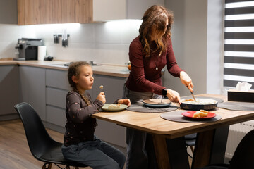 Mom and girl enjoying baked pie at home kitchen table, sweet treats and parenting moment, family dining and happiness together