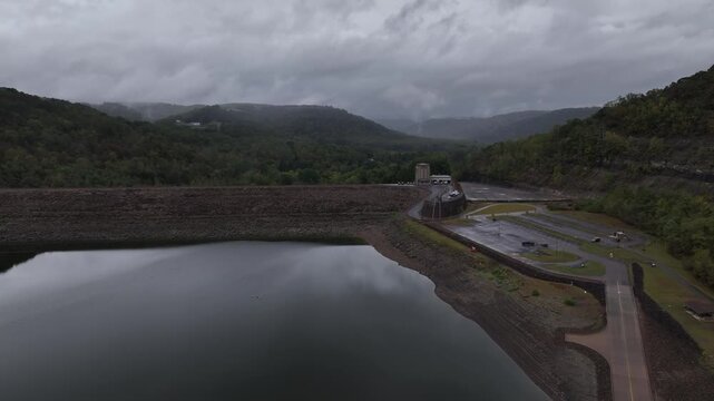 Youghiogheny reservoir lake and dam in Pennsylvania with still calm water and mountains in dense gray clouds and mist