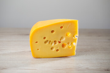 maasdam cheese on wooden background, close-up view