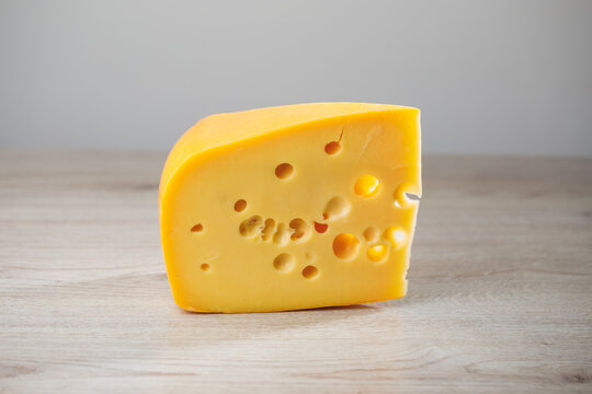 maasdam cheese on wooden background, close-up view