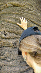Woman hugging a large tree trunk