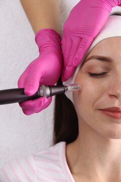 Woman undergoing microneedling procedure in beauty salon, top view