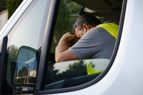 Mature man worker feeling tired stressed in van