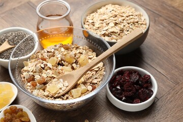 Making granola. Oat flakes with dried fruits in bowl on wooden table, closeup