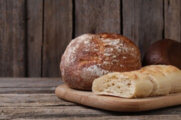 Different types of bread on wooden table, closeup. Space for text