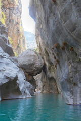 Massive boulder suspended between Goynuk canyon walls, Turkey. Stunning narrow gorge with hanging giant rock above turquoise waters.