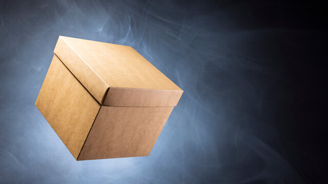 A single cardboard box is suspended in mid air against a dark background