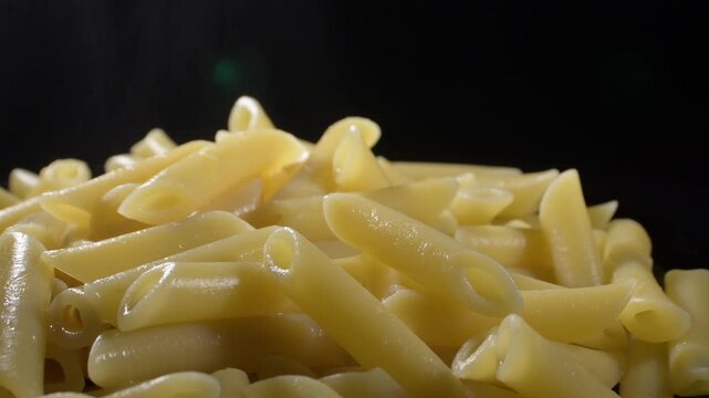 Just boiled macaronis turning in black background