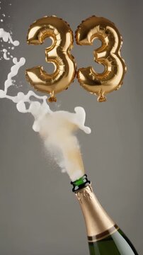 Number 33 balloon with popping champagne bottle. Celebrating a milestone, anniversary or birthday