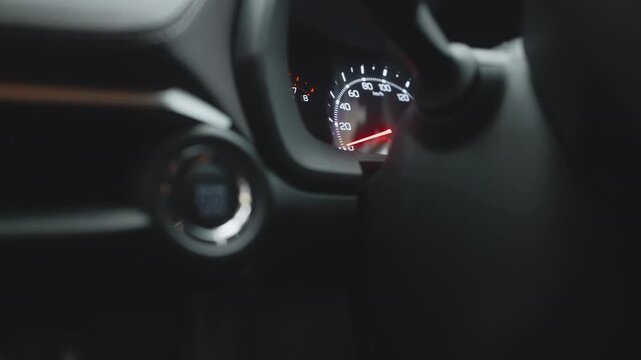 Close-up view of a car dashboard with speedometer and control knobs, showcasing modern automotive design and technology in a sleek interior environment