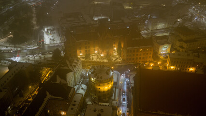 Widok z drona na nocne Stare Miasto w Toruniu, spowite delikatną mgłą. Podświetlone budynki i zabytkowa architektura lśnią w mgiełce, tworząc tajemniczy i nastrojowy miejski pejzaż. © Elżbieta Kaps