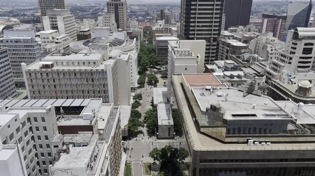 Drone flies away from Ghandi Square in downtown Johannesburg, South Africa on a sunny afternoon