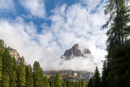 A mountain of the Dolomite Alps or Pale Mountains name from carbonate rock dolomite in Veneto, Italy part of Southern Limestone Alps near Cortina d'Ampezzo surrounded by low hanging white clouds