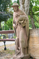 Der gute Hirte vor einem Grabstein auf einem Friedhof in Kaufbeuren © Blende8