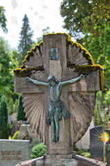 schönes sehr altes Steinkreuz mit Moos bewachsen und der Kreuzigung auf einem Friedhof in Kaufbeuren © Blende8