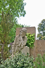 in tiefer Trauer sitzt eine Frau auf einem Grab auf dem Friedhof in Kaufbeuren © Blende8