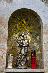 sehr schönes Marienbildnis mit dem Kind in einer Nische des Grabstein mit Mosaik verziert und Grabkerzen auf  dem Katholischen Friedhof in Kempten Allgäu © Blende8