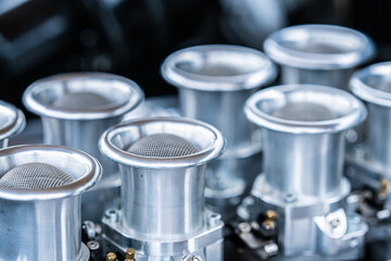 Close up view of polished aluminium velocity stacks on performance engine.