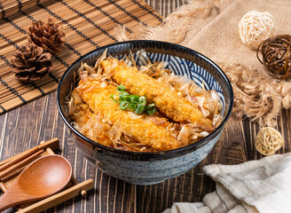 Crispy golden fried fish served over rice with delicate bonito flakes in a rustic bowl setting