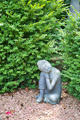 Buddha Statue auf rot weißem  Kies auf dem Katholischen Friedhof in Kempten - Allgäu © Blende8