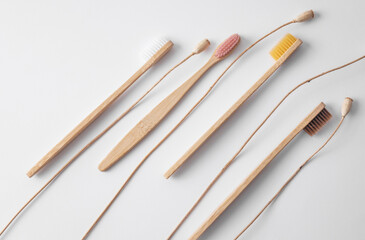 Wooden eco friendly natural toothbrushes and dry grass on white background