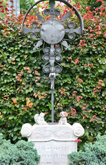 schönes Eisenkreuz auf einem Stein und einem kleinen Hund auf dem Katholischen Friedhof in Kempten - Allgäu © Blende8